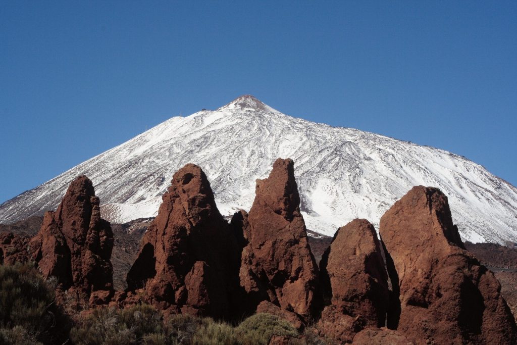 Mount Teide in the Snow. Volacnic rock formations in the foreground. 