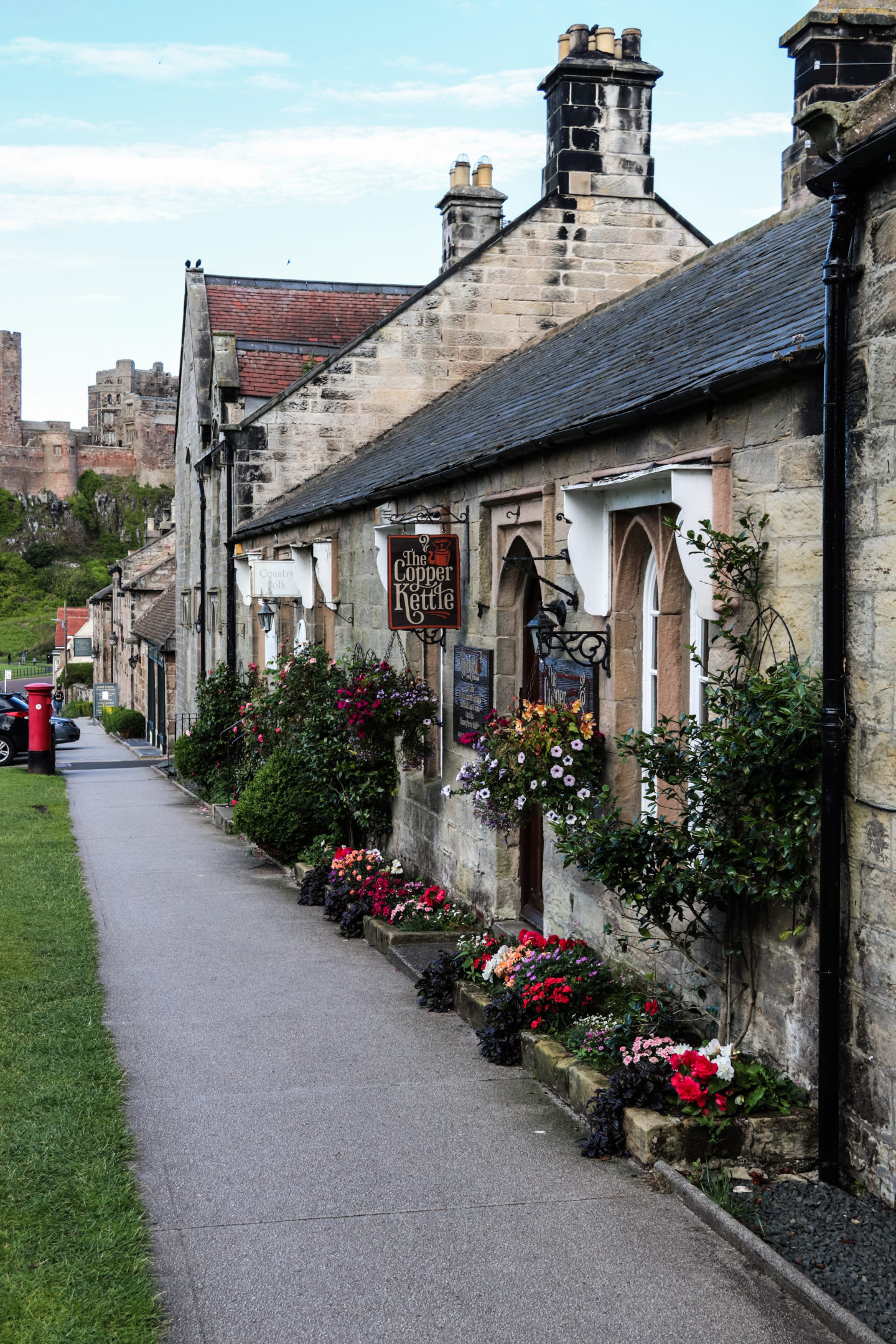 Picture perfect shops in Bamburgh Village - a cafe called the Copper Kettle with Bamburgh Castle in the background. 