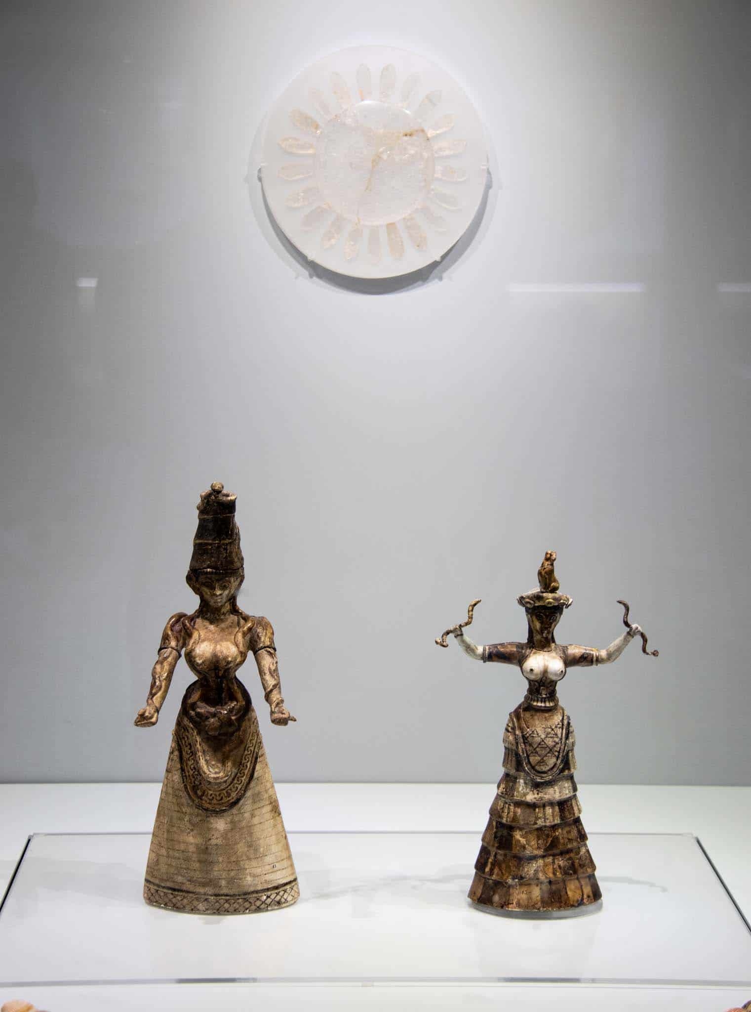 Minoan Snake Goddess and Priestess in the Heraklion Archaeological Museum. The snake goddess has snakes wrapped around her arms. The priestess holds a snake in each hand and has a Monkey on her head. Yes Louis - there's a monkey on her head!
